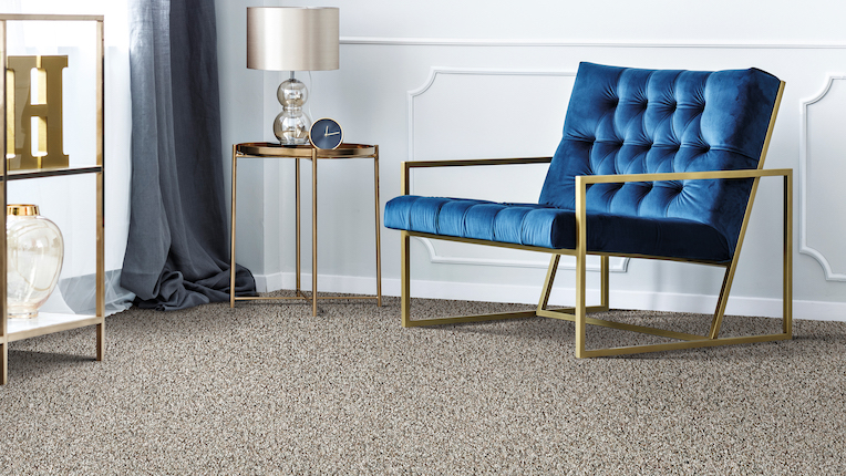 textured grey carpets in a living room with a blue velvet chair